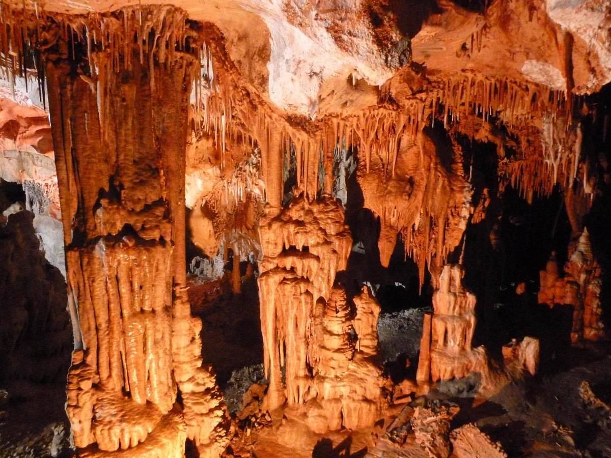 A lit cave chamber in Lehman Caves with a paved walkway, railings, and dramatic limestone formations in Great Basin National Park