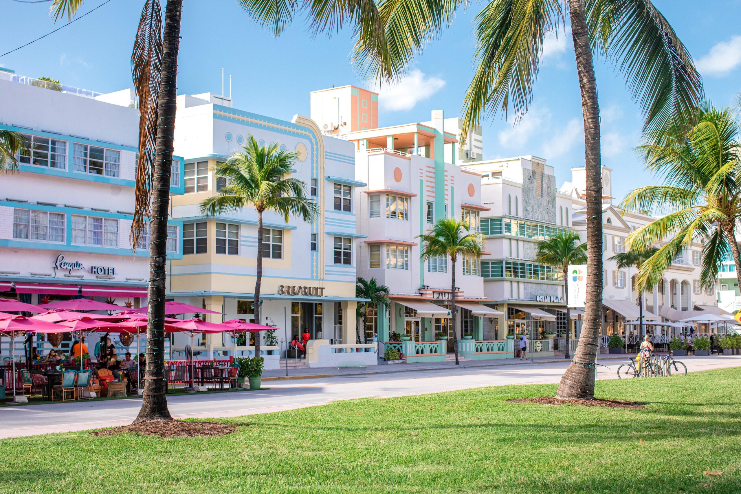 A real photo of pastel Art Deco buildings along Ocean Drive in South Beach with palm trees and warm late-afternoon light