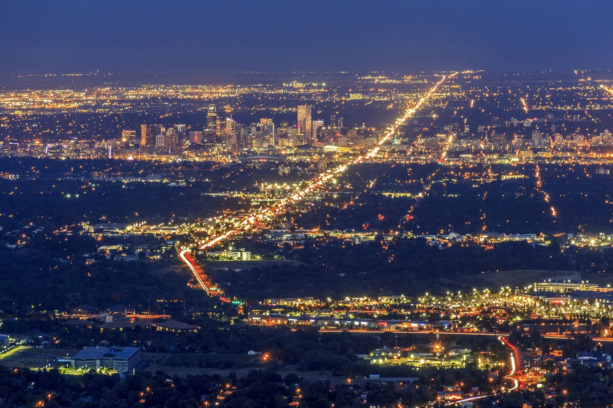 A real photograph from Lookout Mountain near Denver, Colorado showing a wide overlook with the city skyline in the distance under a clear blue sky
