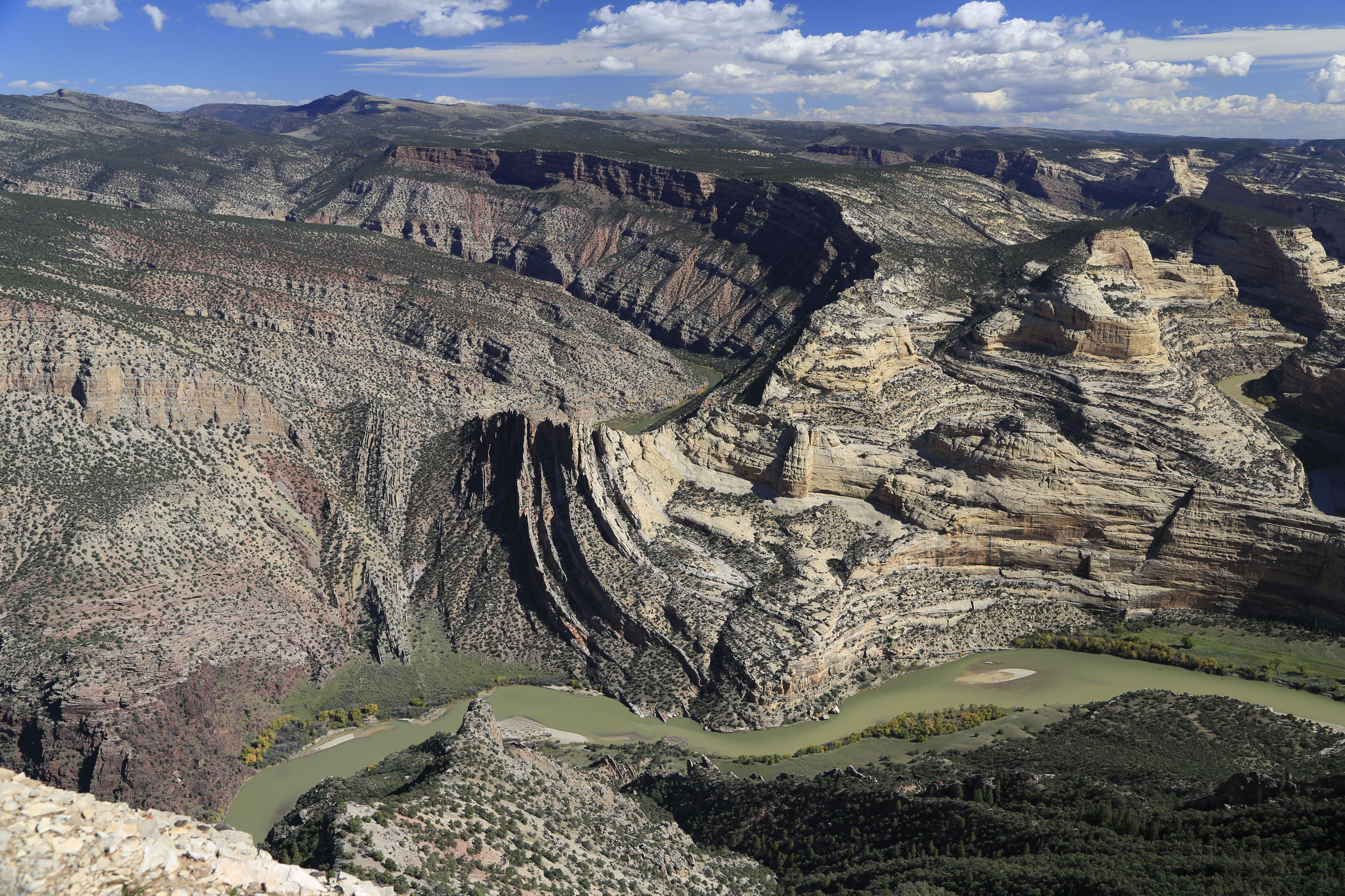 A real photograph from a Harper's Corner Road overlook showing layered canyon ridges and deep river-carved gorges on the Colorado side of Dinosaur National Monument