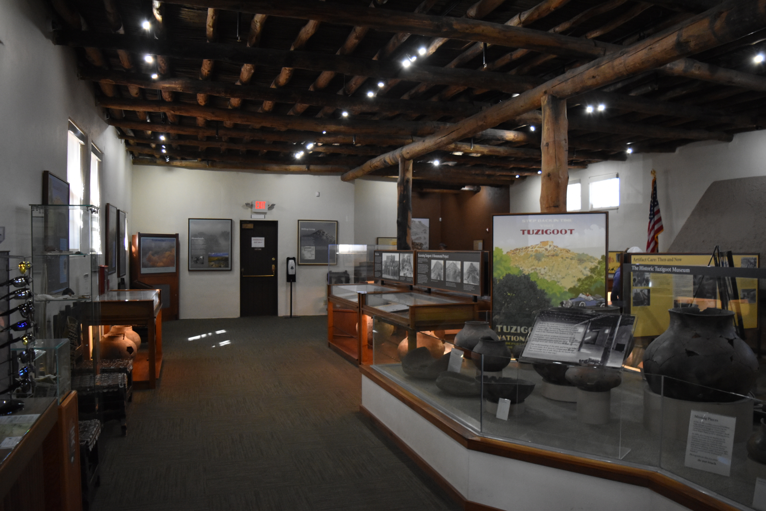 A real photograph inside the Tuzigoot visitor center showing museum-style exhibits and interpretive displays in a softly lit gallery space