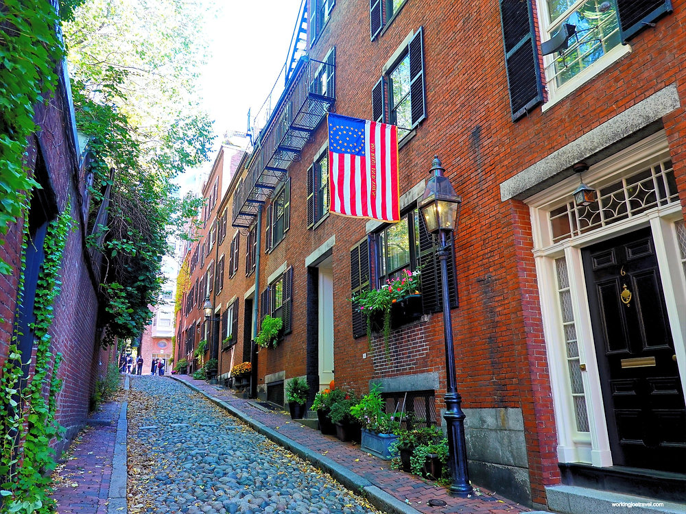 A real photograph of Copley Square in Boston with historic buildings, pedestrians, and late afternoon light