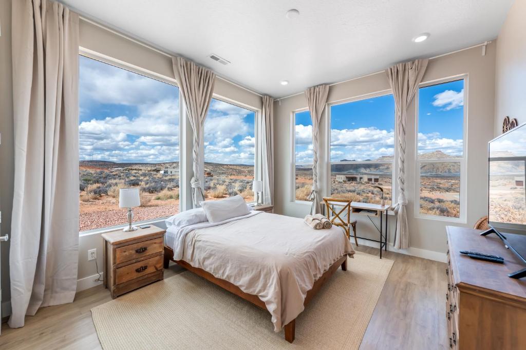 A real photograph of a simple modern hotel room in Page, Arizona with morning light coming through a window and desert hills visible outside