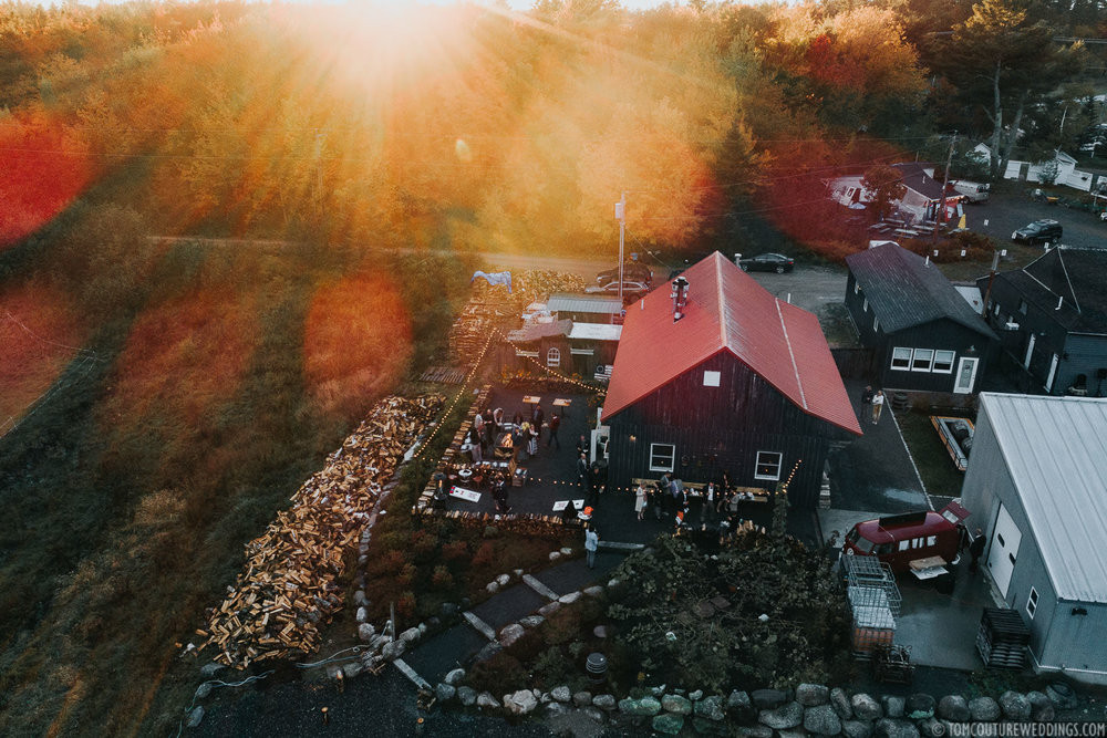 A real photograph of a traveler holding a hot coffee cup near a window in a cozy Bar Harbor cafe in the early morning light