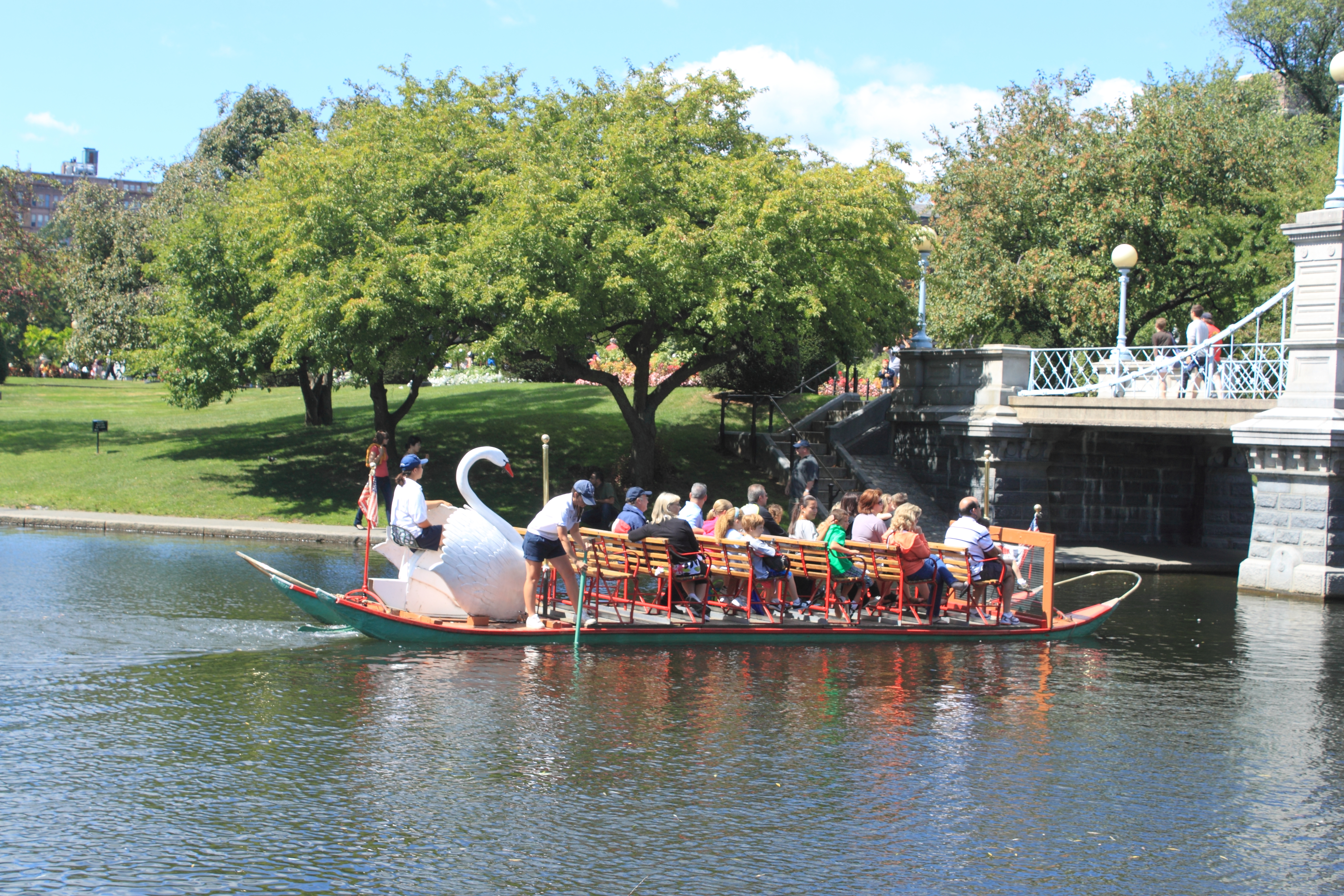 A real photograph of the Boston Public Garden lagoon with Swan Boats and spring flowers under soft morning light