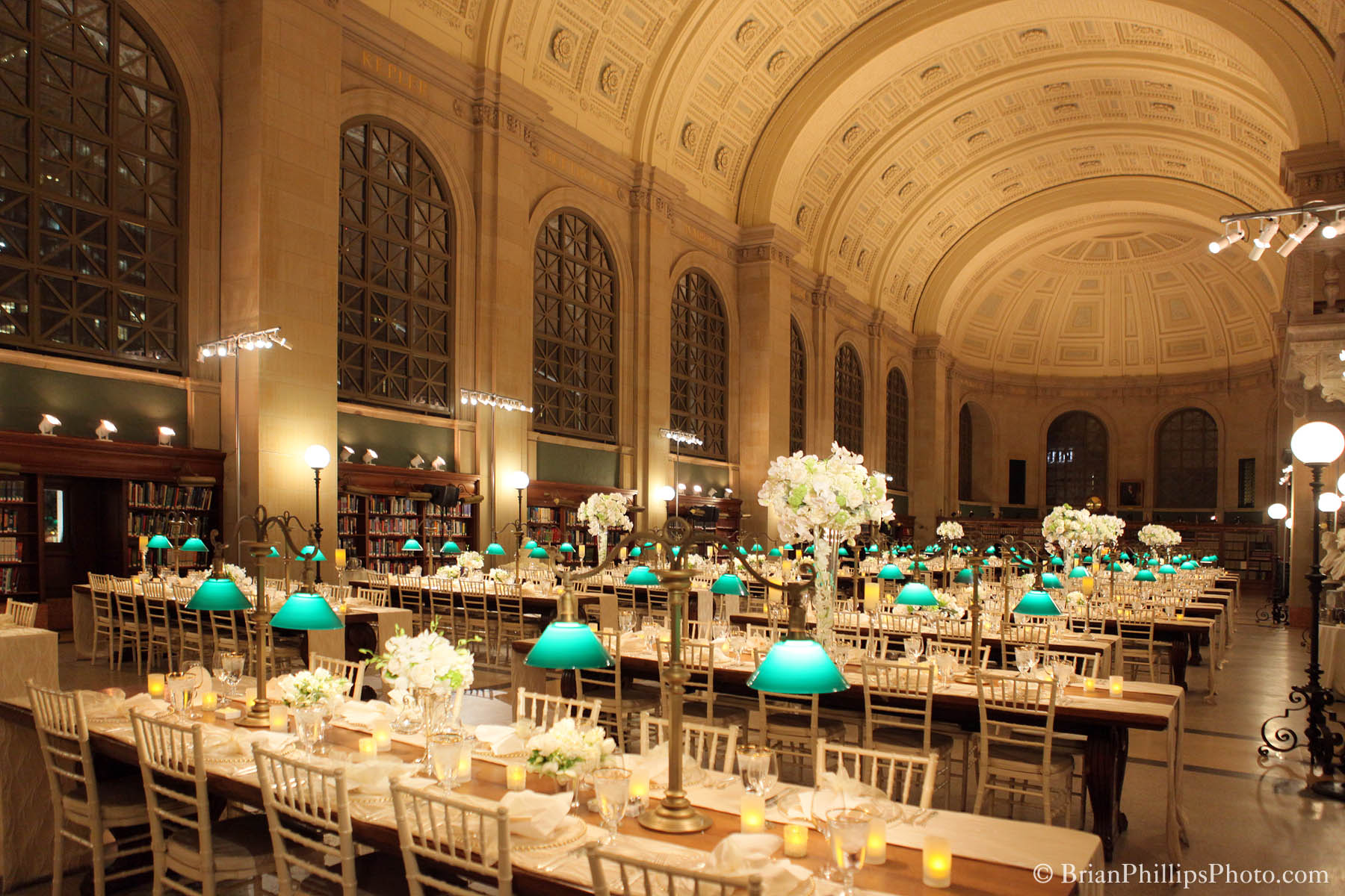 A real photograph of the Boston Public Library Bates Hall reading room with long wooden tables and arched windows