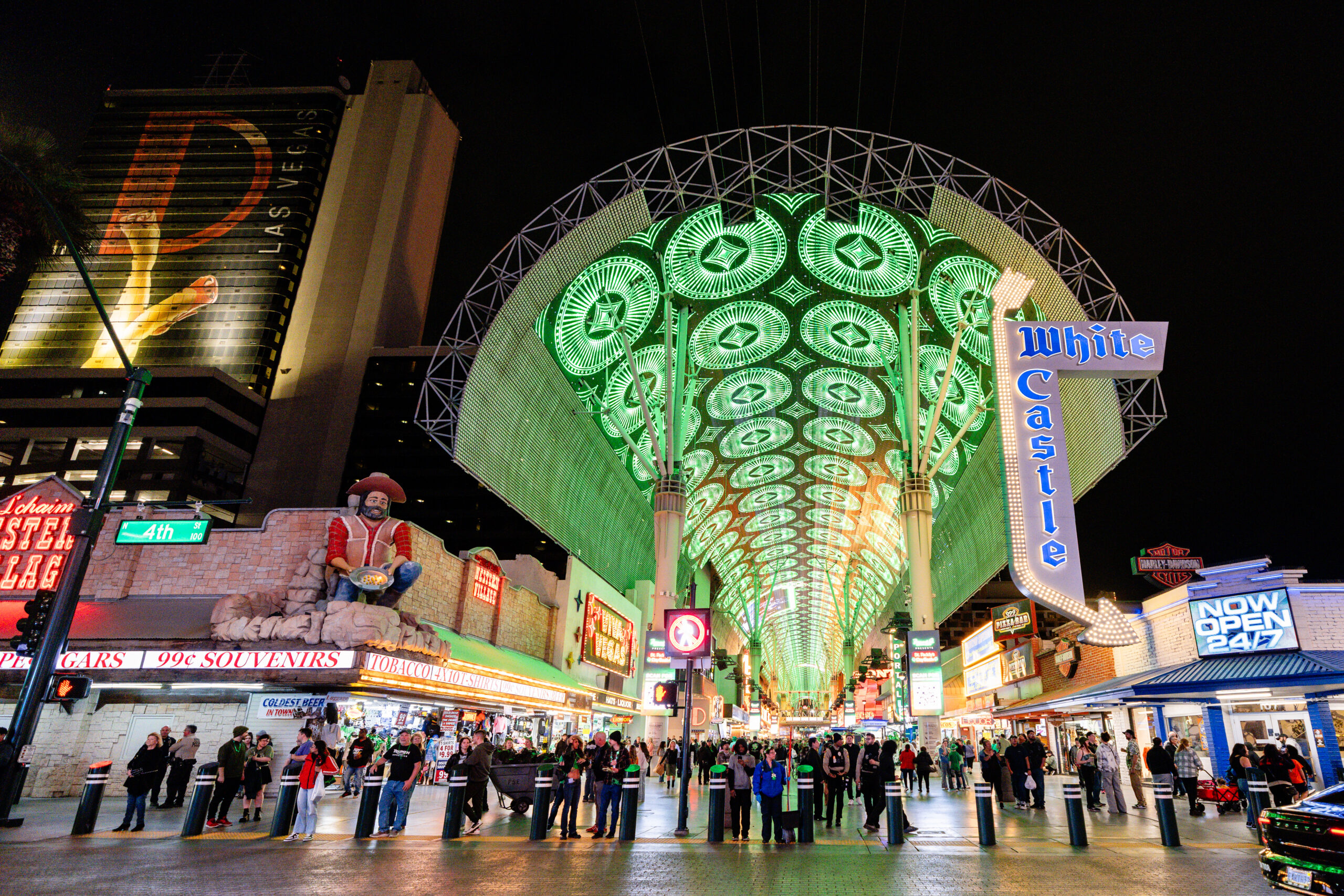 A real photograph of the Fremont Street Experience in Las Vegas at night, with the glowing LED canopy overhead and crowds walking below