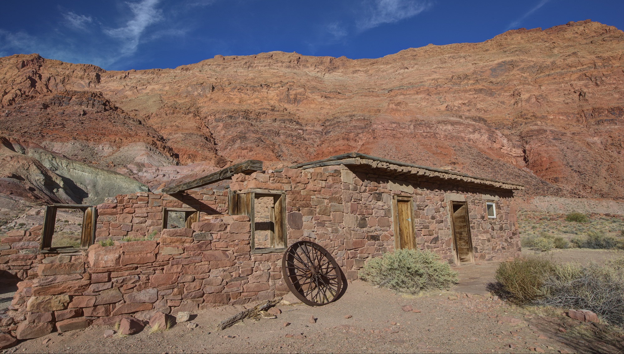 A real photograph of the historic area at Lee's Ferry with rustic buildings and desert vegetation under bright sun in Glen Canyon National Recreation Area