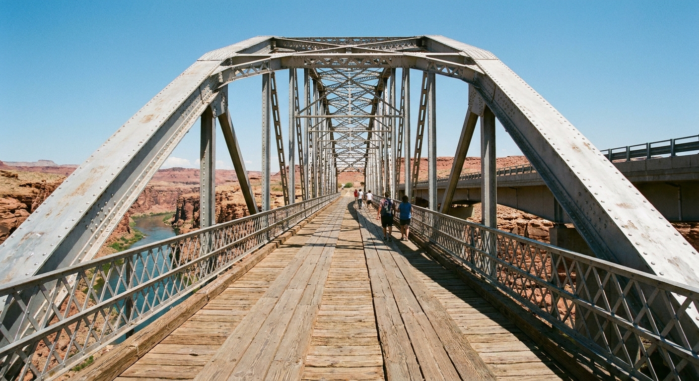 A real photograph of the pedestrian walkway on Navajo Bridge in Marble Canyon, Arizona with steel bridge structure and the Colorado River visible far below