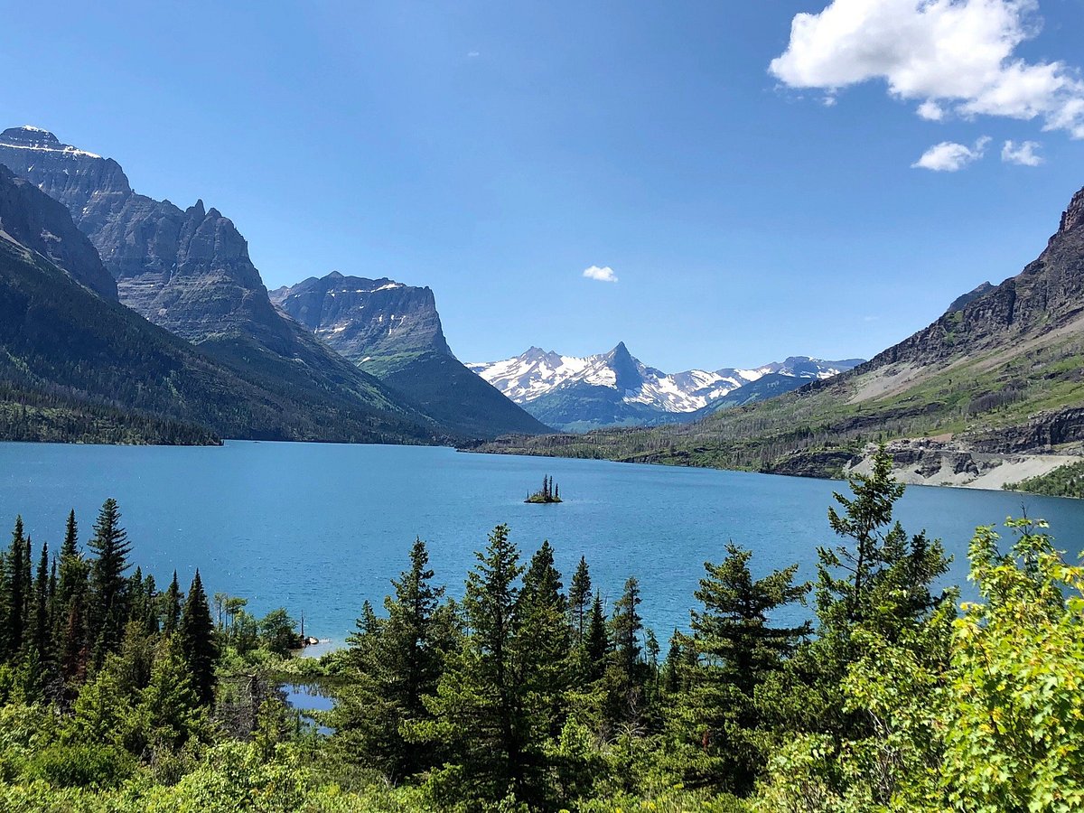 Afternoon view across St. Mary Lake toward Wild Goose Island with mountains layered in the background and rippled blue water in the foreground