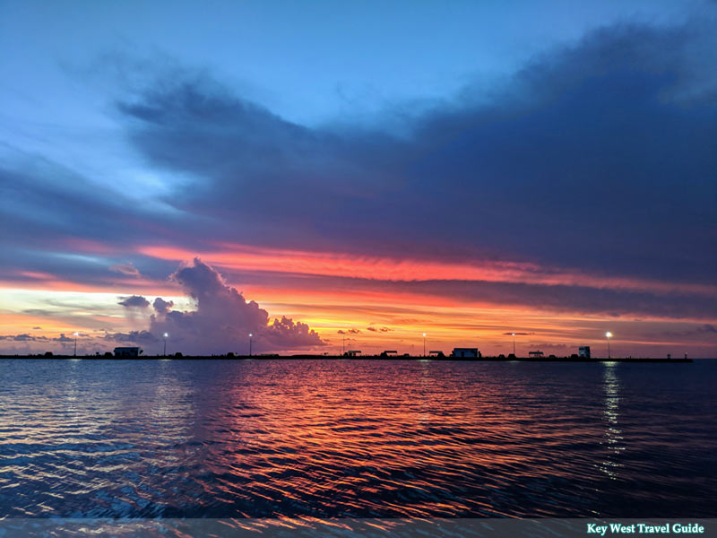 Boats in Key West harbor at sunset with warm light reflecting on the water