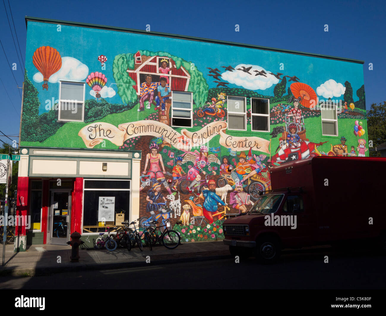 Colorful street mural in Portland's Alberta Arts District with pedestrians walking past small storefronts on a bright, cool day