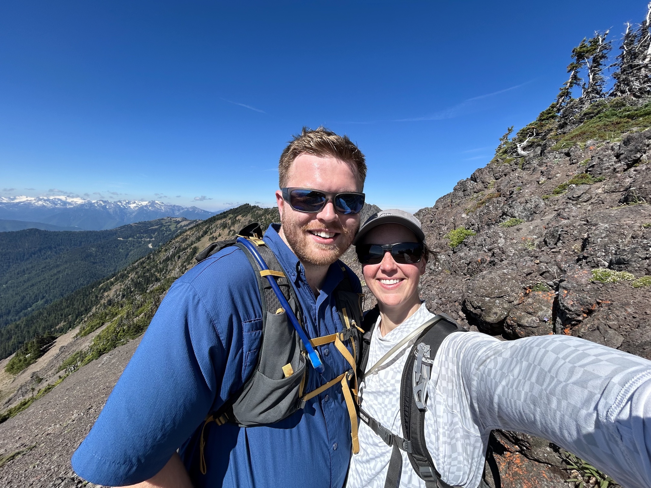 Hikers climbing a rocky switchback trail at high altitude under clear skies, realistic outdoor photography
