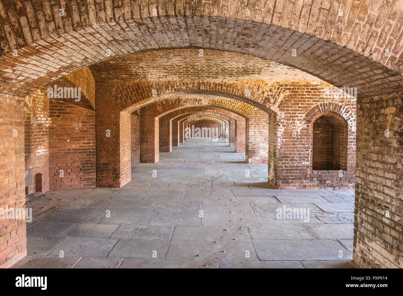Inside Fort Jefferson with long brick archways and visitors walking through