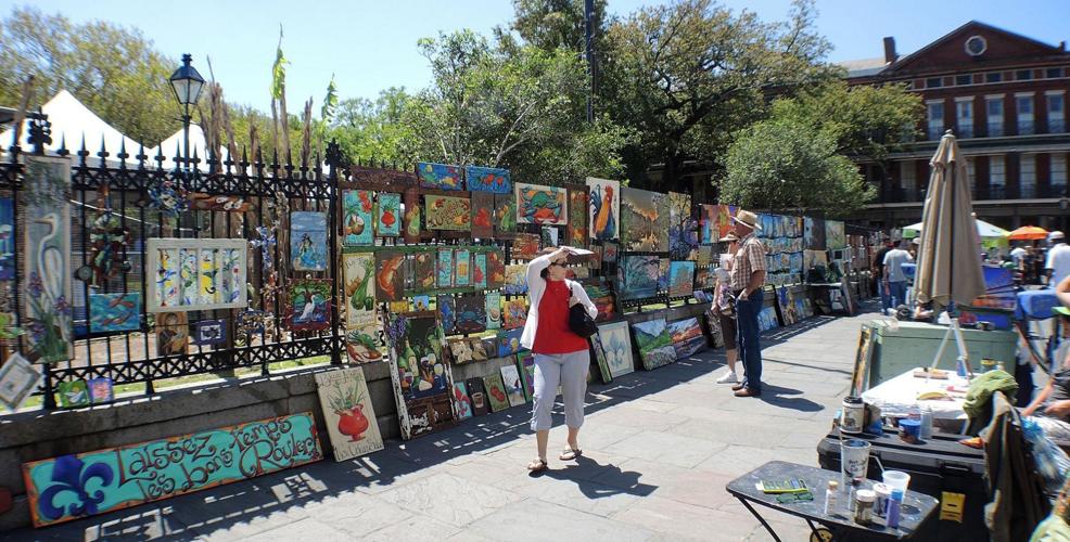 Jackson Square in New Orleans in the morning with local artists setting up their displays and St. Louis Cathedral in the background, real travel photography style