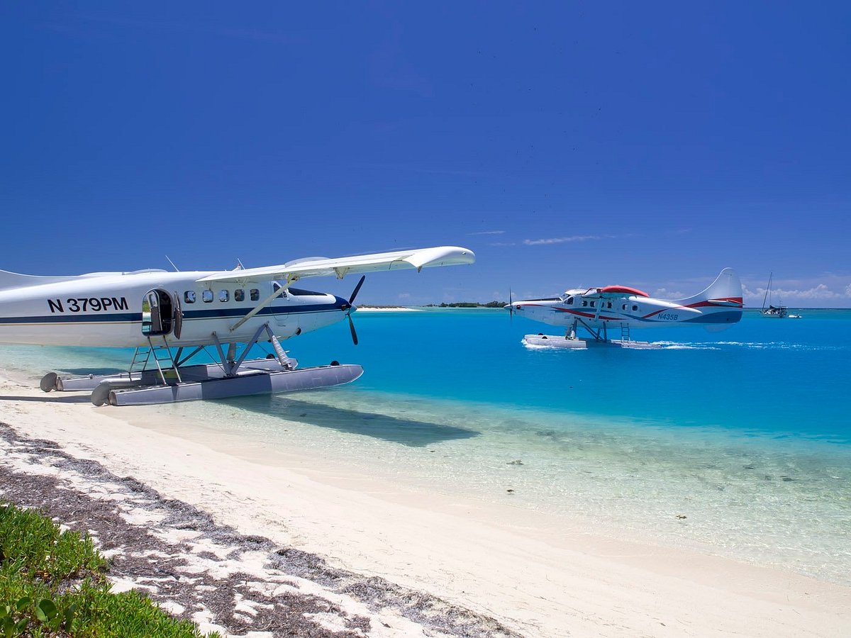 Small seaplane flying over bright turquoise water near the Florida Keys on a clear day